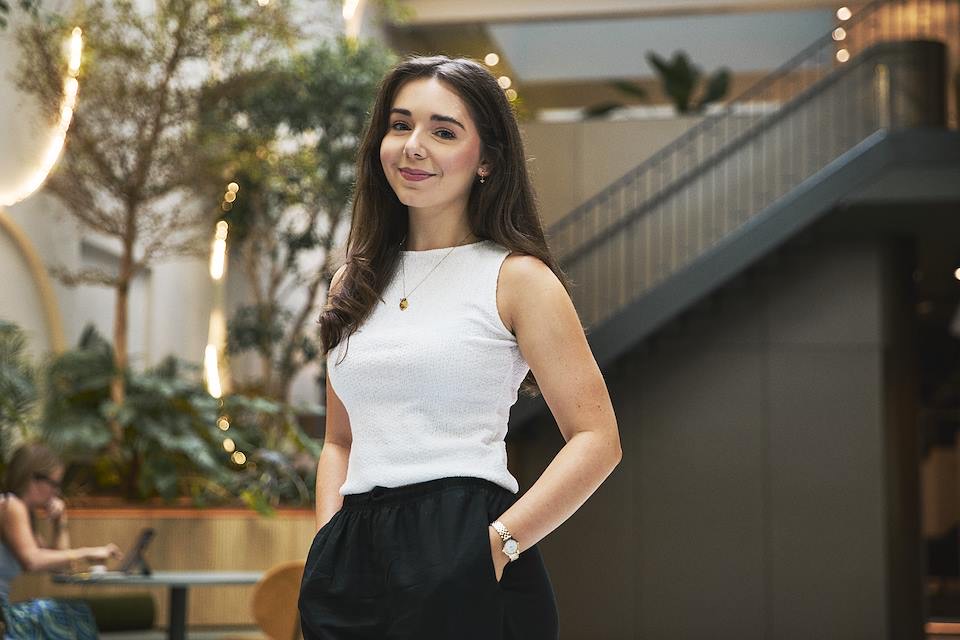 Sophie, founder of She Uses AI, smiling in a bright office atrium